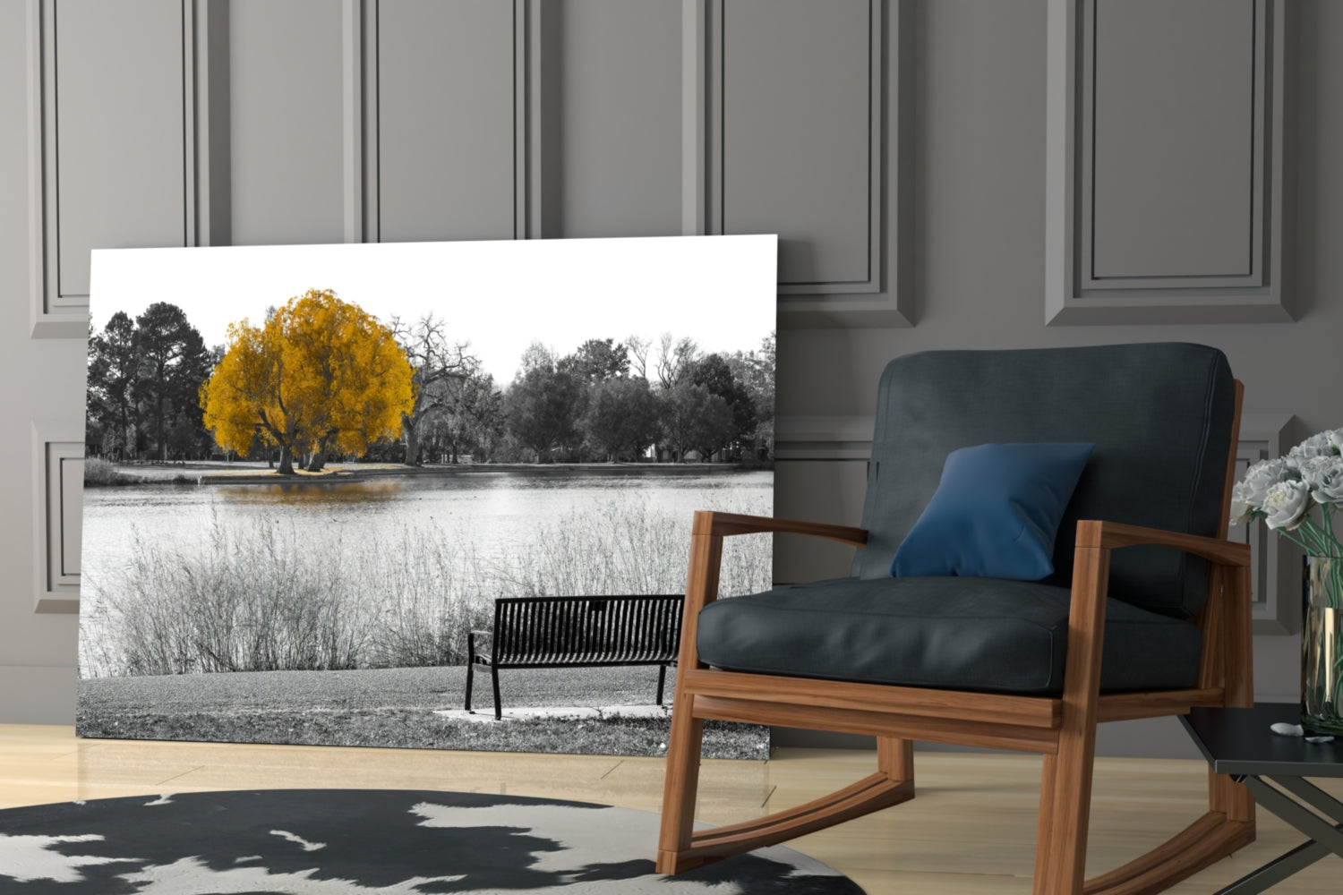 Glass wall art displaying a selective-color landscape with a golden yellow tree beside a lake, mounted in a modern living room setting.