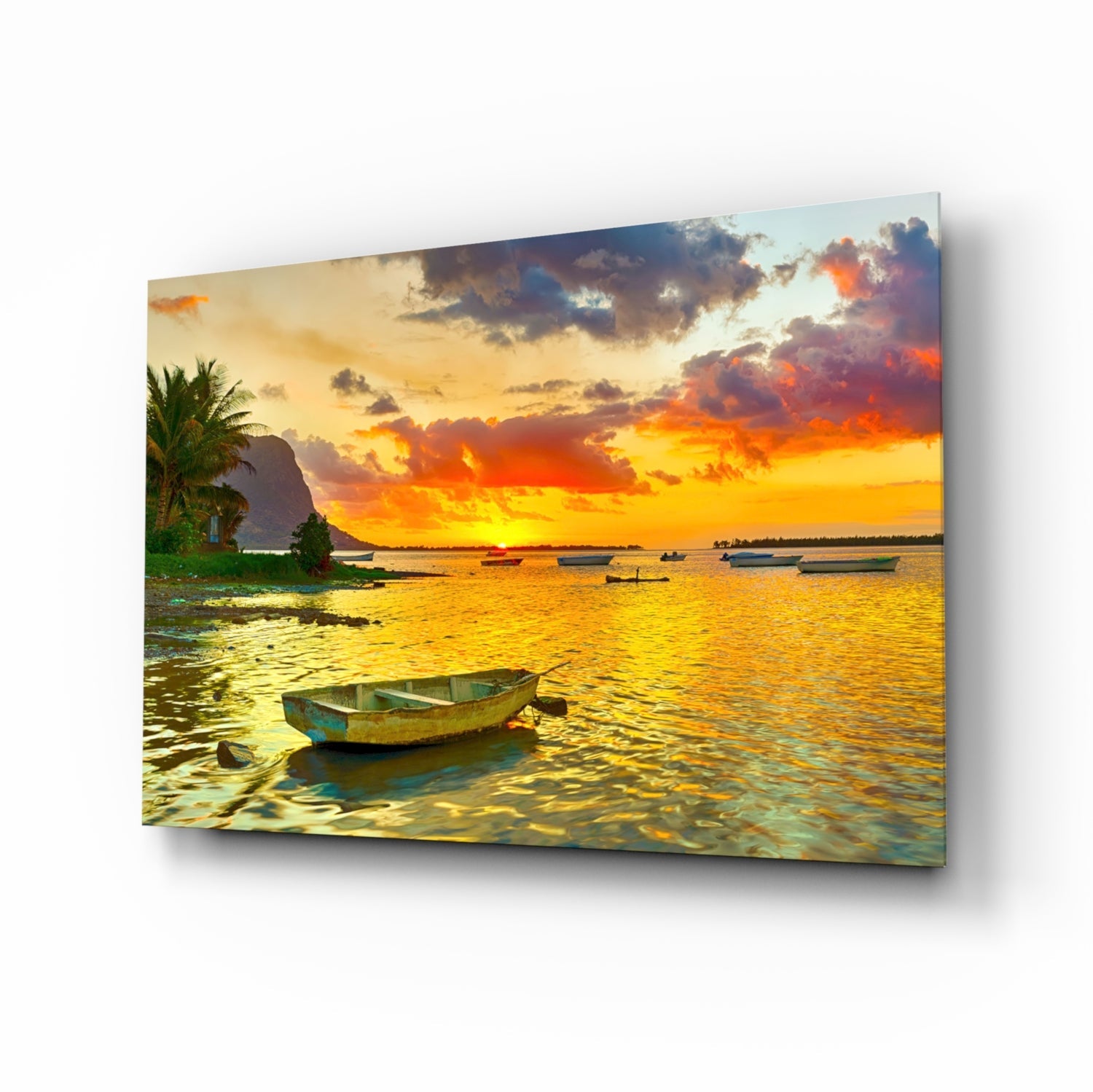 Canvas print of a tropical sunset seascape with fishing boats, palm trees, and golden-orange sky reflected on calm water.