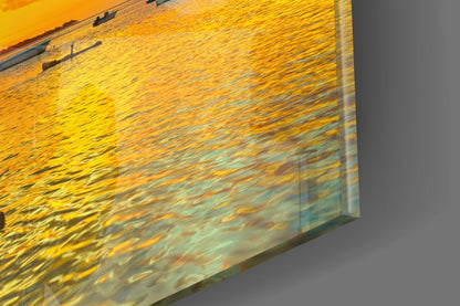 Angled close-up view of a framed photograph showing golden sunset light reflecting on rippled water.