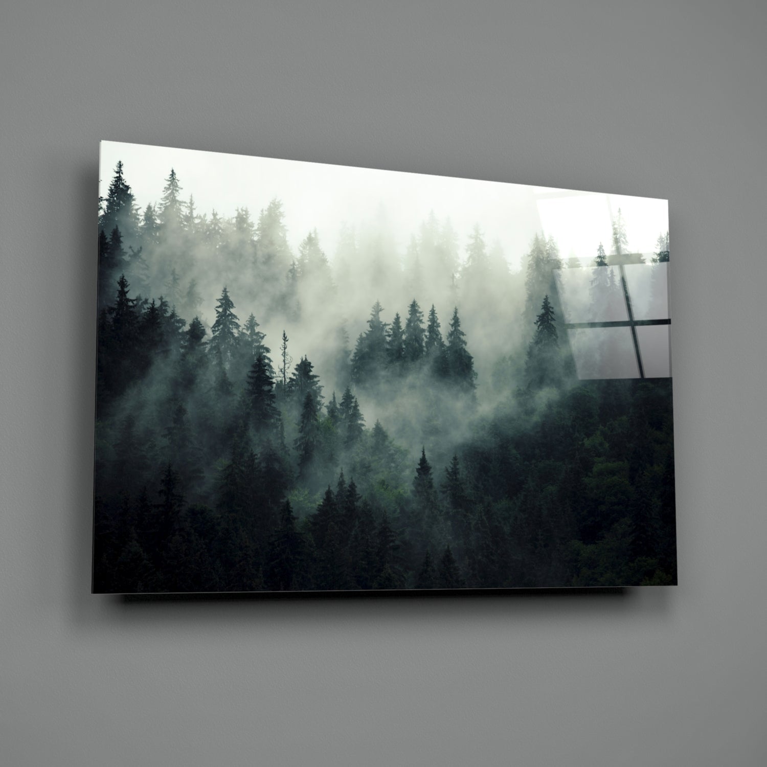 Misty coniferous forest landscape printed on glass wall art with geometric line overlay, mounted on gray wall.