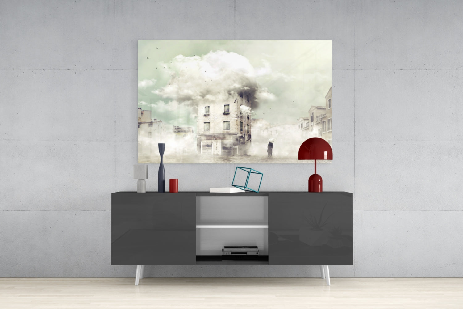 Modern living room styled with gray media console displaying surreal foggy cityscape glass wall art above, accented with red lamp and decorative objects.