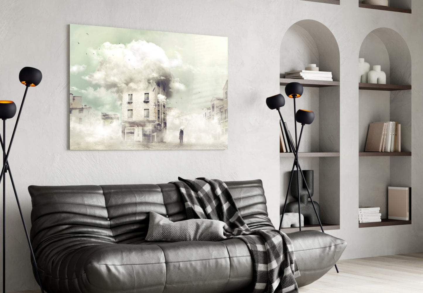Fog Glass Wall Art displaying a misty urban street scene with buildings and clouds, displayed above a black leather sofa in a modern living room interior.