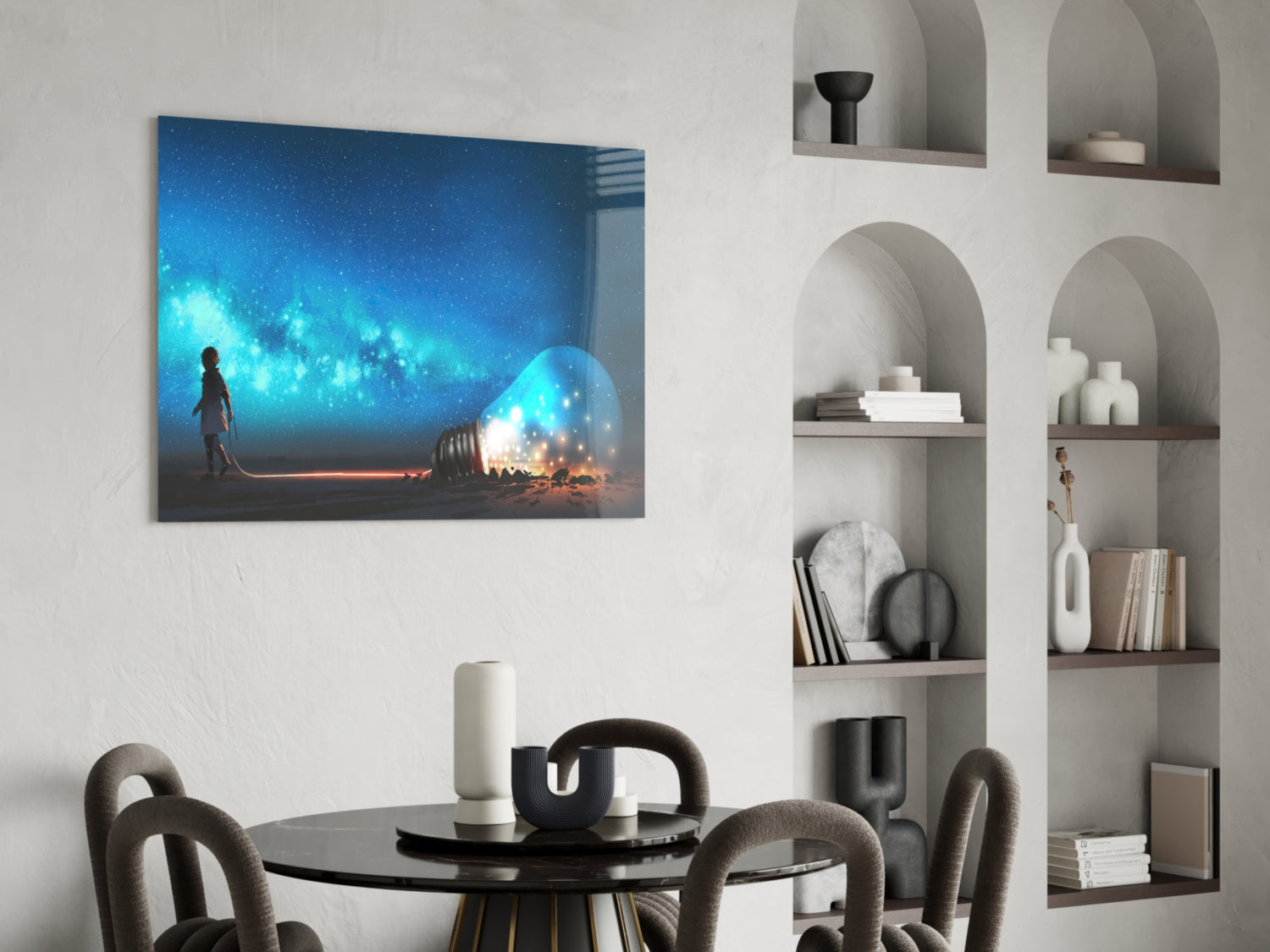 Glass wall art depicting a silhouetted figure beside a glowing orb against a blue starry sky, displayed above a round dining table.