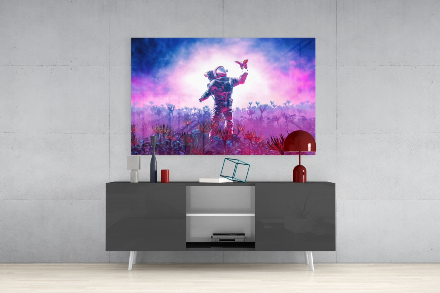 Glass wall art displaying a neon-lit astronaut in a vibrant purple and pink alien landscape with butterflies, mounted above a dark media console.