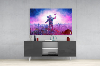 Glass wall art displaying a neon-lit astronaut in a vibrant purple and pink alien landscape with butterflies, mounted above a dark media console.