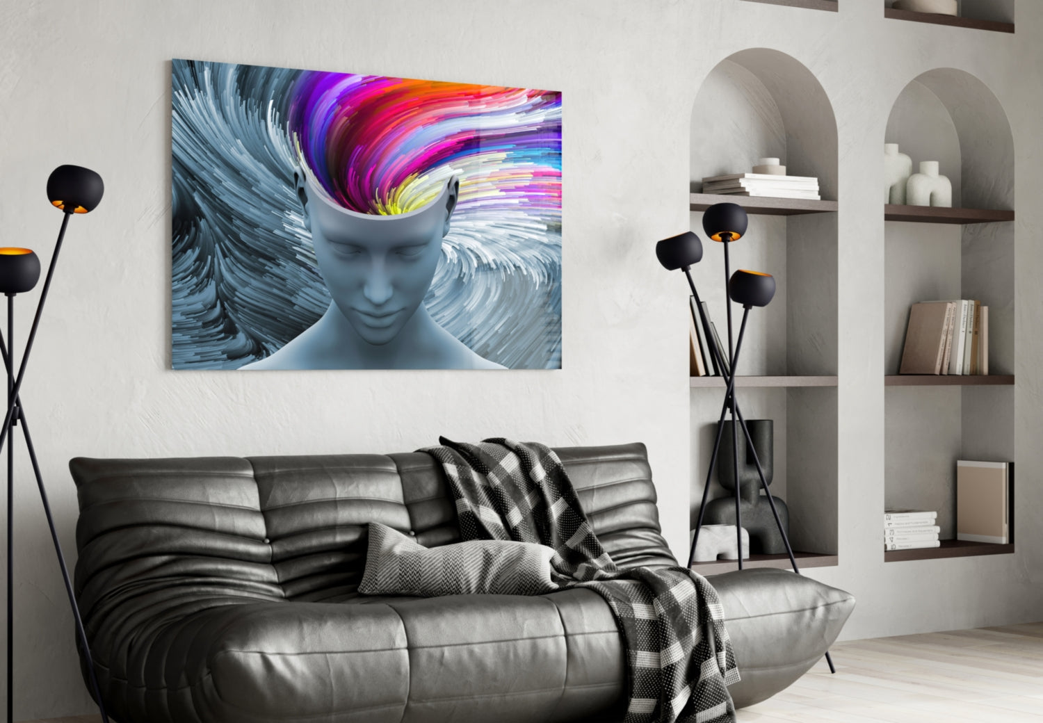 Modern living room with colorful abstract head canvas above black leather sofa and white shelving unit.