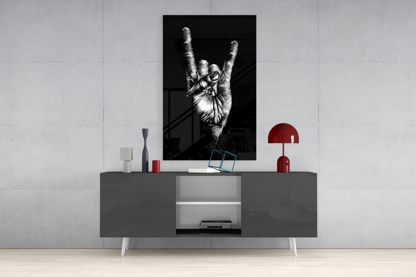Black and white framed print of a hand making a peace sign displayed above a gray media console with red decorative accessories.
