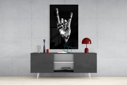 Black and white framed print of a hand making a peace sign displayed above a gray media console with red decorative accessories.