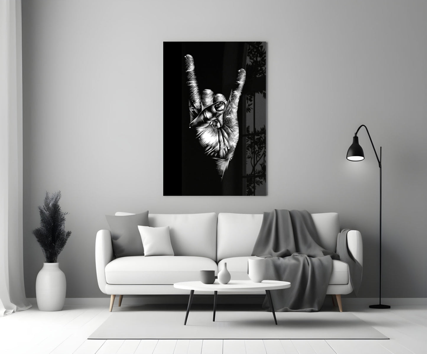 Black and white glass wall art depicting a hand making a peace sign gesture, displayed above a white sofa in a minimalist living room.