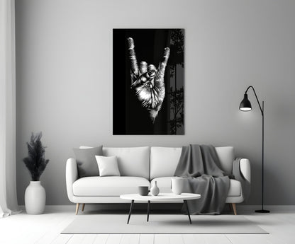 Black and white glass wall art depicting a hand making a peace sign gesture, displayed above a white sofa in a minimalist living room.