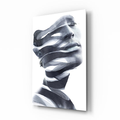 Monochrome glass wall art featuring a man's face in profile with abstract white ribbon-like strips obscuring his features, mounted at an angle.