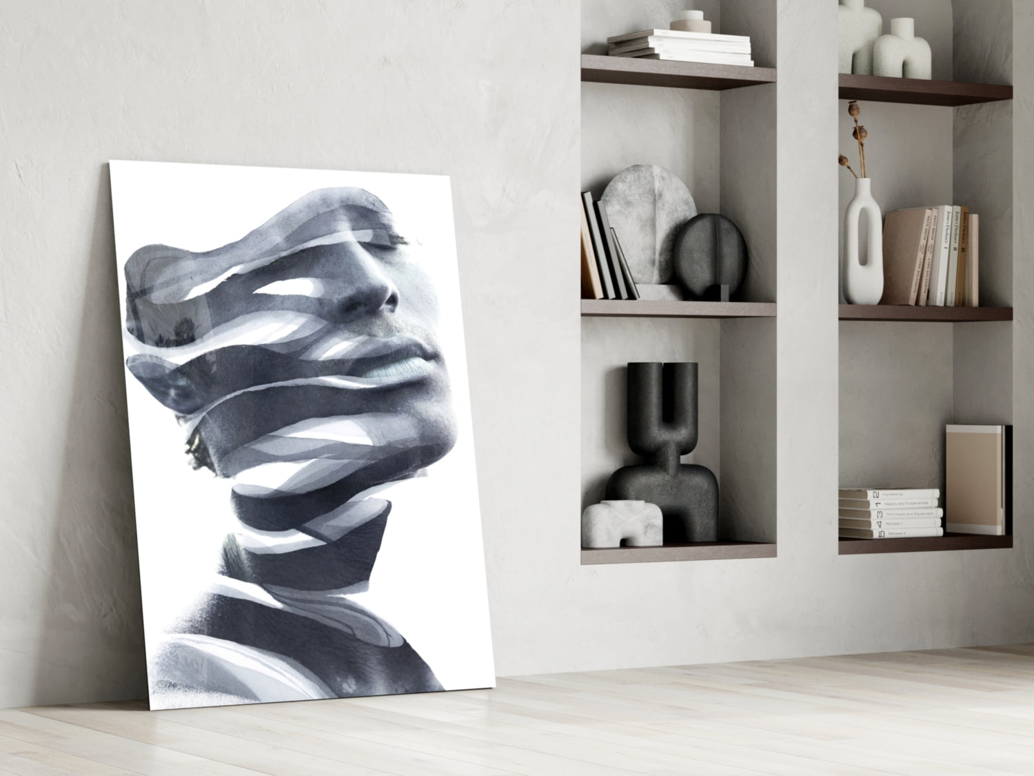 Black and white abstract portrait glass art leaning against white wall beside built-in shelving with decorative objects.