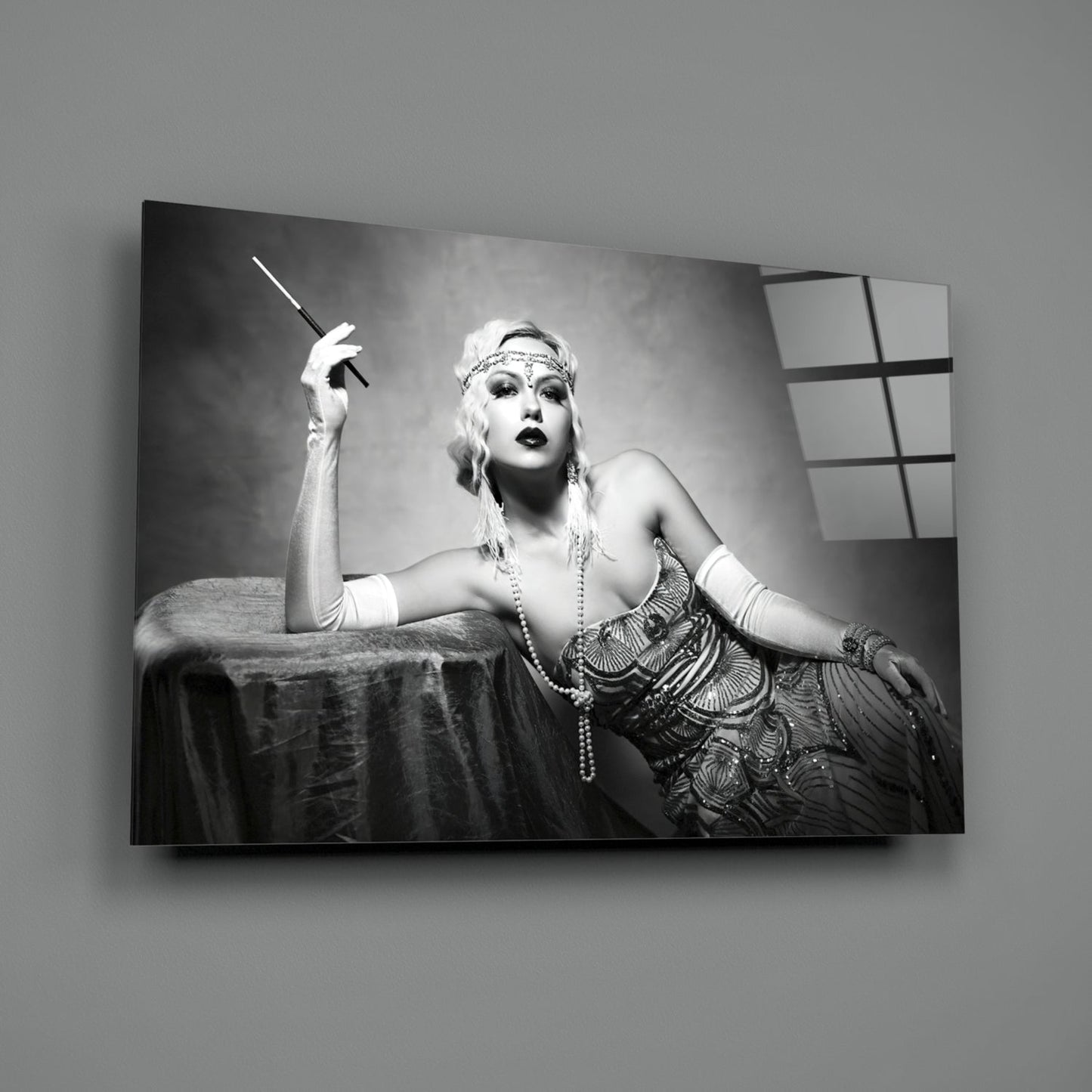 Black and white Art Deco portrait on glass wall art depicting glamorous woman with cigarette holder and period jewelry against draped fabric backdrop.