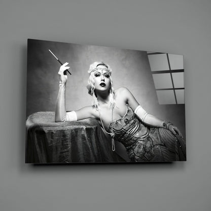 Black and white Art Deco portrait on glass wall art depicting glamorous woman with cigarette holder and period jewelry against draped fabric backdrop.