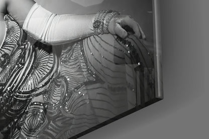 Close-up detail of ornate black and silver beaded fringe against white fabric and gray wall surface.