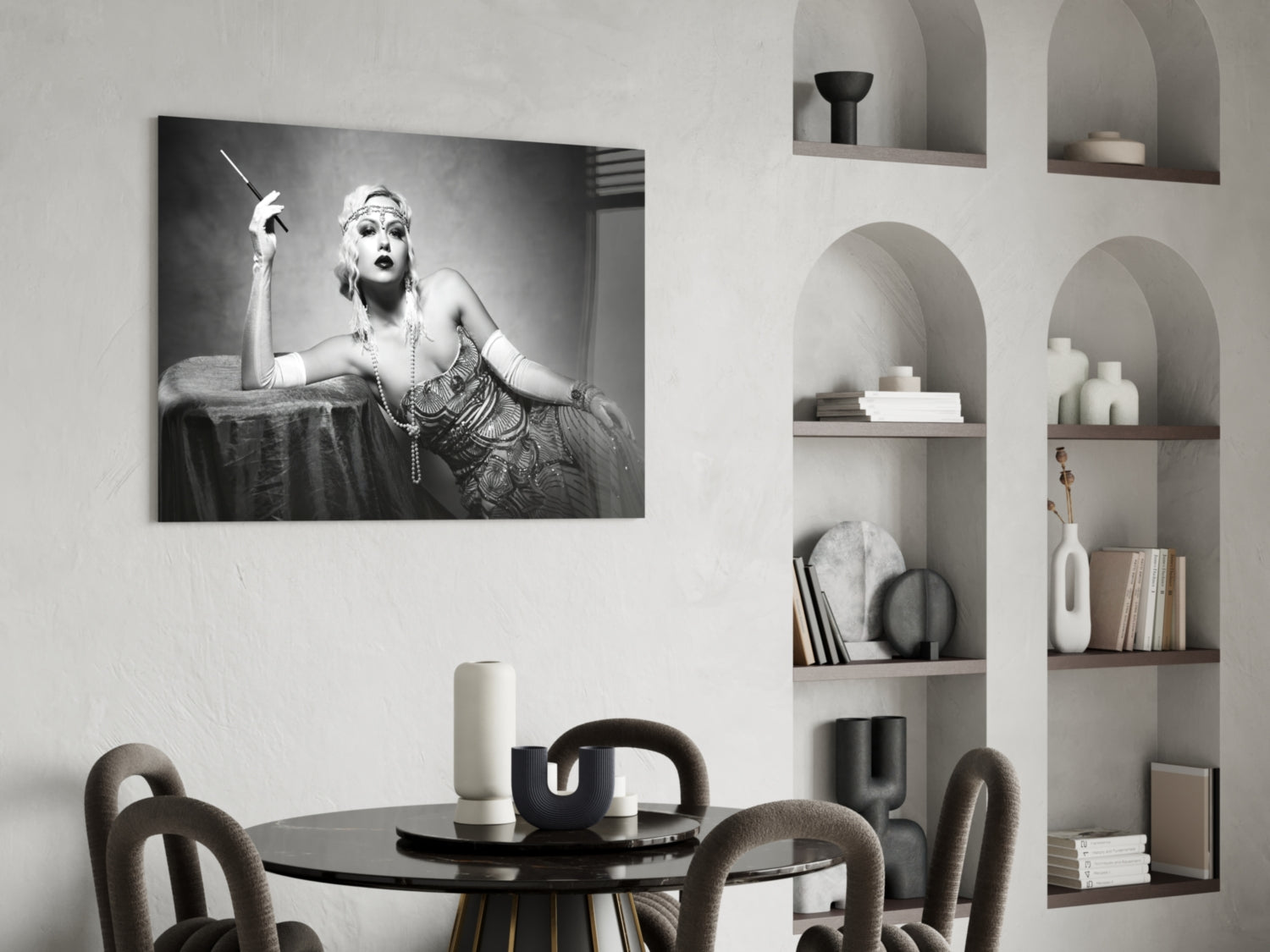 Black and white glass wall art depicting a glamorous 1920s woman with cigarette holder and headpiece, displayed above a round dining table in a modern interior.