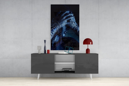 Deep Thought Glass Wall Art displayed above a dark gray media console, showing blue-toned portrait of hands with decorative objects and red lamp nearby.