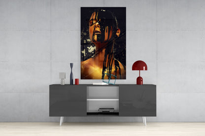 Stain glass wall art depicting a woman's face in warm golden and orange tones displayed above a gray media console in a modern interior setting.