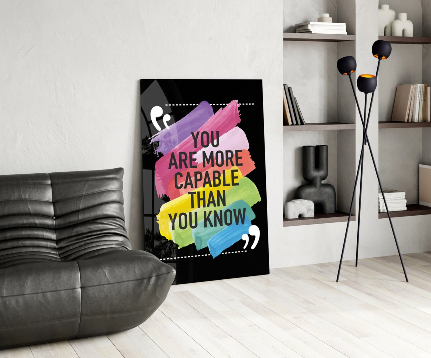 Motivational glass wall art with colorful rainbow brushstrokes and "You Are More Capable Than You Know" text displayed in modern living room setting.