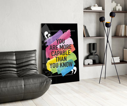 Motivational glass wall art with colorful rainbow brushstrokes and "You Are More Capable Than You Know" text displayed in modern living room setting.