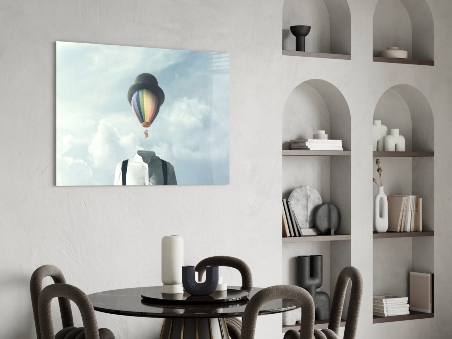 Surreal glass art depicting a figure with a colorful hot air balloon head against cloudy sky, displayed above a round black dining table.