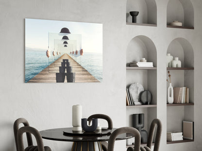 Surreal glass wall art depicting a figure in dark clothing on a wooden pier with receding mirrors showing repeated bowler hats, displayed above a black round table in a minimalist interior.