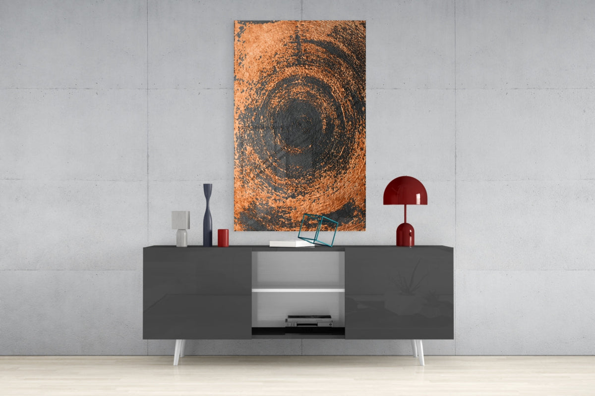 Copper spiral swirl glass wall art displayed above a gray media console with white shelving and red decorative accessories.