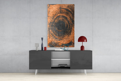 Copper spiral swirl glass wall art displayed above a gray media console with white shelving and red decorative accessories.