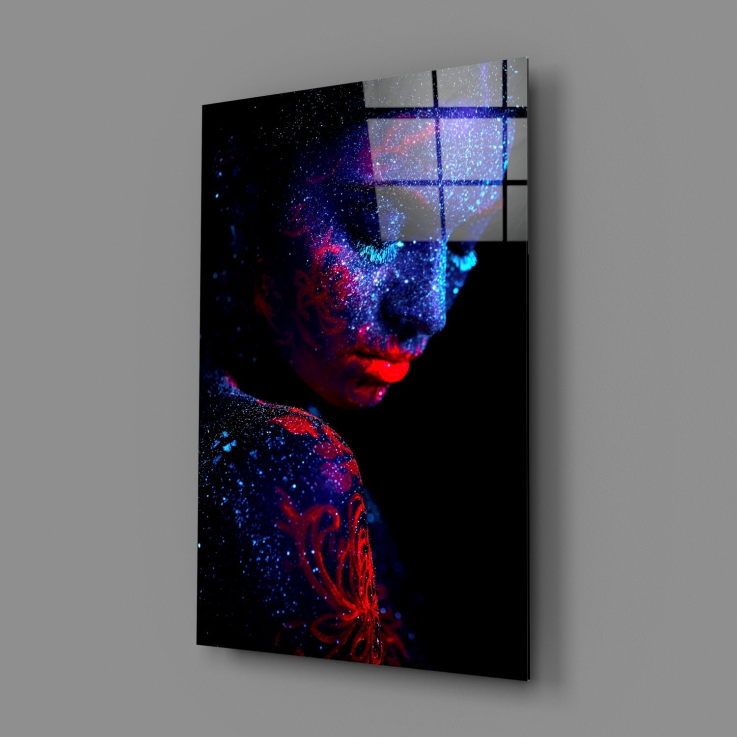 Angled view of glass wall art featuring a portrait with red and blue particle effects dispersing across black background, with grid overlay visible on upper right section.