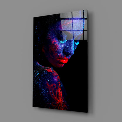 Angled view of glass wall art featuring a portrait with red and blue particle effects dispersing across black background, with grid overlay visible on upper right section.