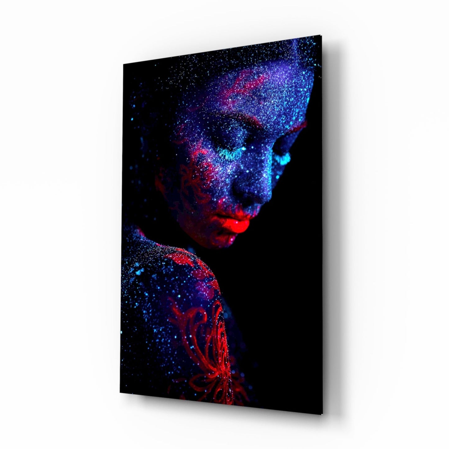 Angled side view of glass wall art displaying a portrait made of blue, red, and cyan particles against black background.
