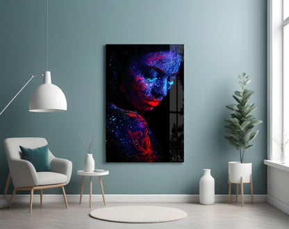 Modern interior room with neon-lit portrait glass art displaying blue and red glowing face against teal wall.