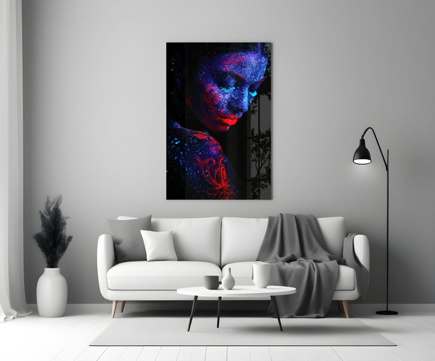 Serenity Glass Wall Art displayed above a white sofa in a modern living room, showing a portrait with neon blue and red particles on black background.