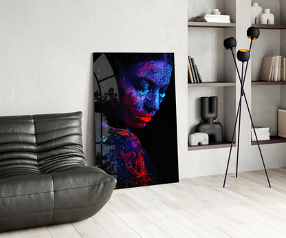 Modern living room interior featuring neon-lit portrait glass art with blue and red particles on black background, leaning against wall beside gray sofa.