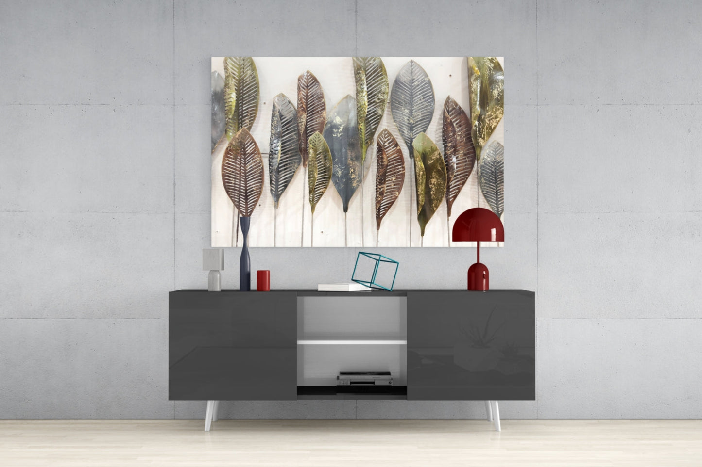 Glass wall art featuring illustrated feathers in gold, brown, and gray tones displayed above a dark gray media console in a modern interior setting.