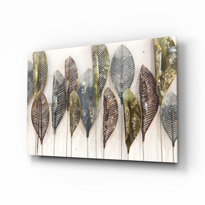 Angled perspective view of glass wall art displaying metallic feathers in brown, gold, and gray tones on cream background.