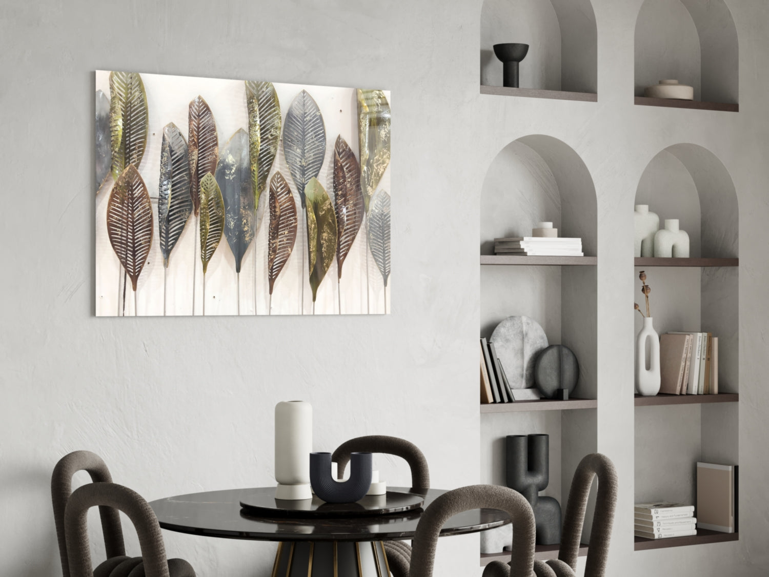 Feathers glass wall art with gold, brown, and gray botanical leaf designs displayed above a black round dining table with gray chairs.