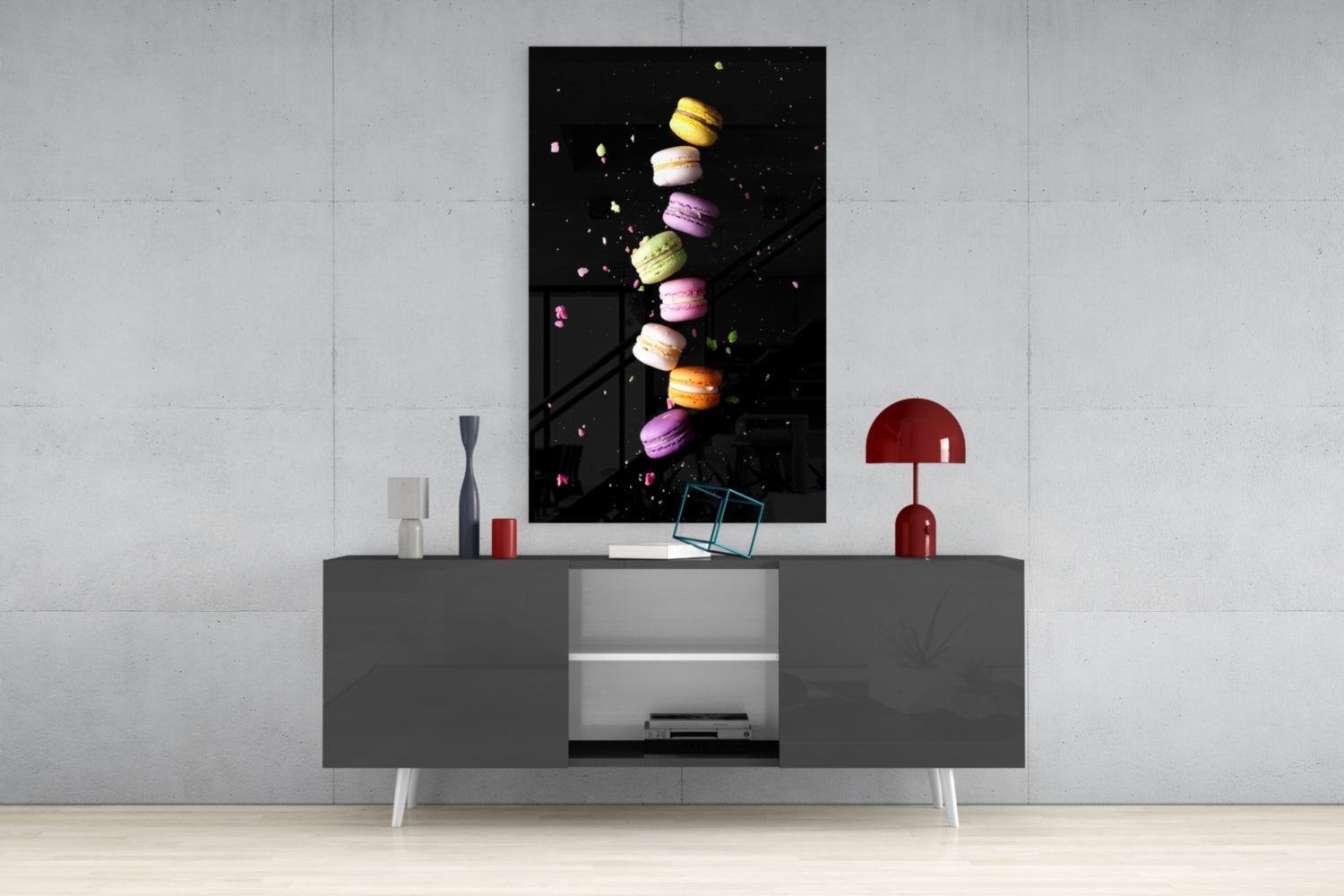 Colorful macarons in yellow, pink, and purple arranged vertically on black glass art displayed above a gray media console.