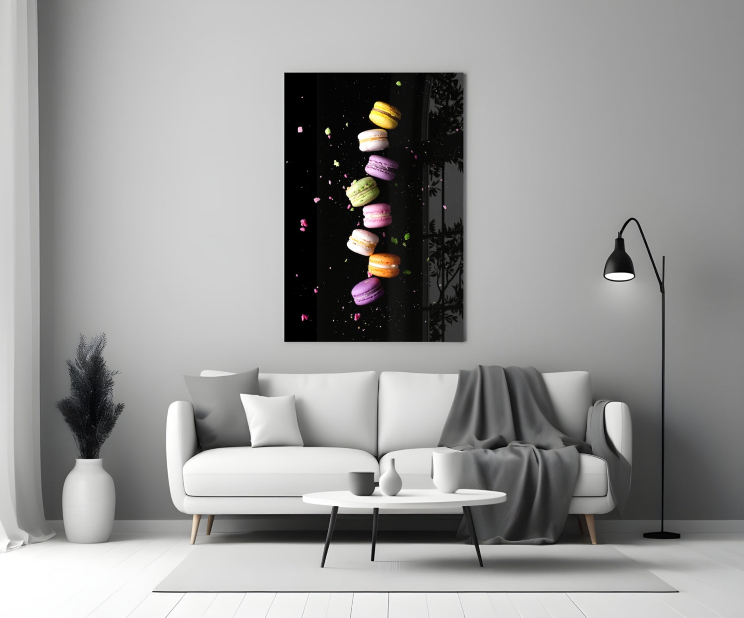 Colorful macarons stacked vertically on black background displayed as glass wall art above white sofa in modern living room.