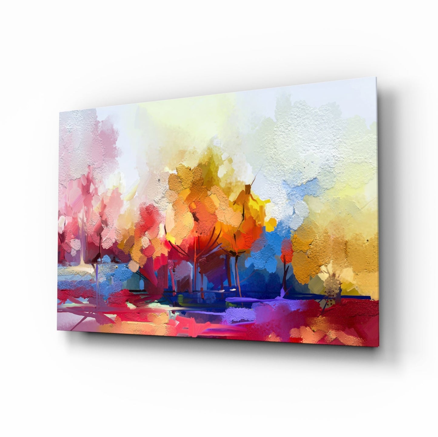 Angled perspective of colorful glass wall art depicting abstract trees in vibrant reds, yellows, blues, and pinks with textured surface detail.