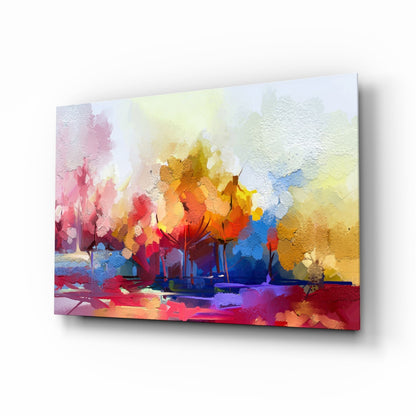 Angled perspective of colorful glass wall art depicting abstract trees in vibrant reds, yellows, blues, and pinks with textured surface detail.