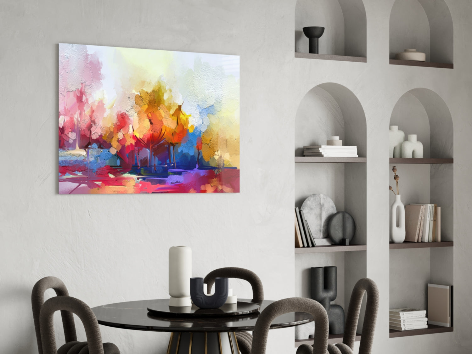 Vibrant abstract watercolor tree painting with pink, yellow, orange, and blue hues displayed above a black dining table.