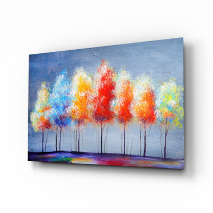 Angled view of glass wall art depicting colorful trees with red, yellow, and blue foliage against a blue sky and multicolored ground.