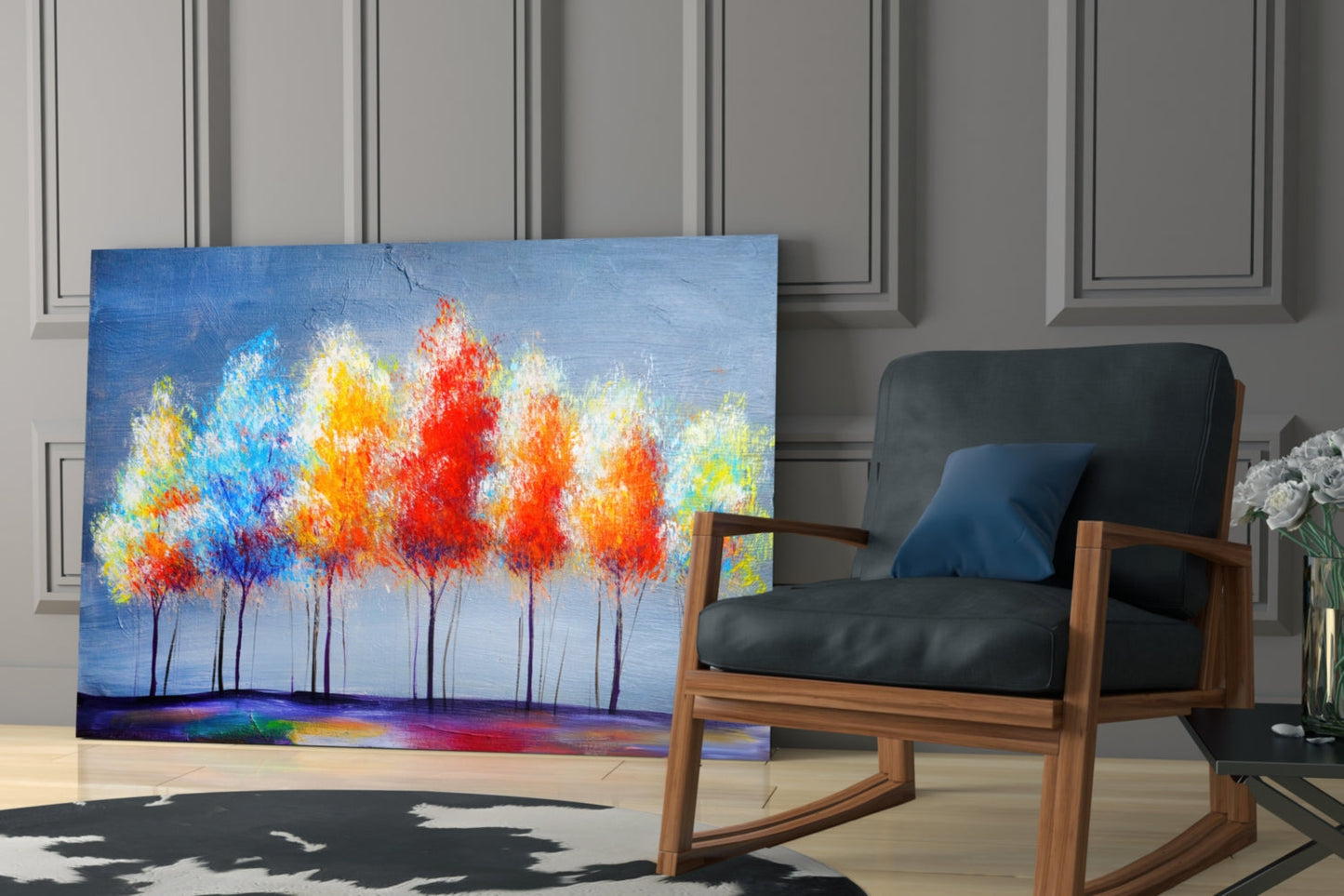 Colorful abstract tree painting displayed leaning against wall beside mid-century wooden chair in modern living room setting.