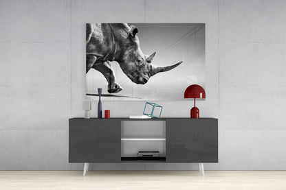 Black and white glass wall art of a rhino's head displayed above a gray modern console table with red decorative accents.