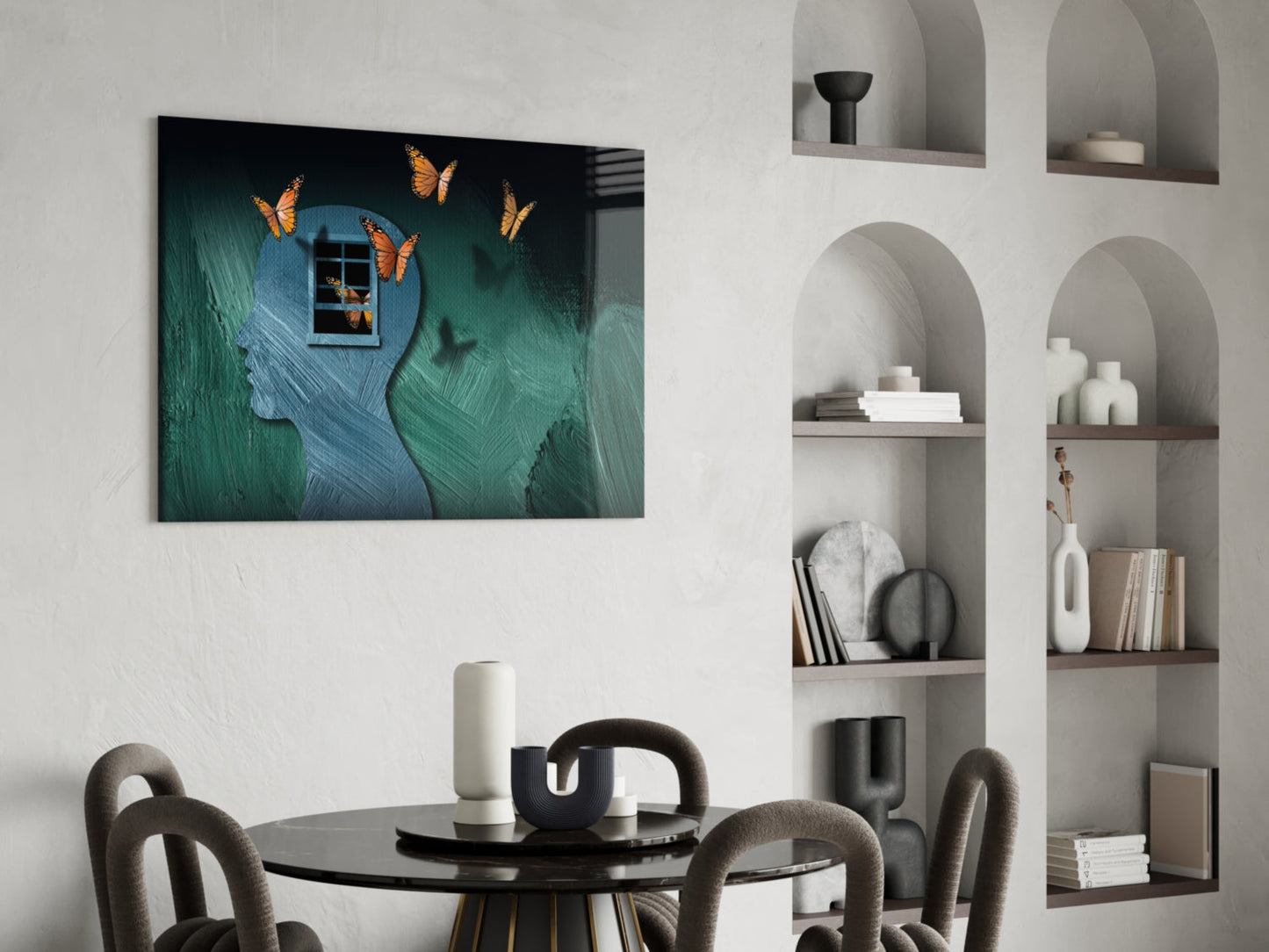 Butterfly Effect glass wall art displayed above a black dining table in a modern room with white built-in shelving.
