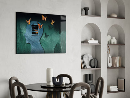 Butterfly Effect glass wall art displayed above a black dining table in a modern room with white built-in shelving.