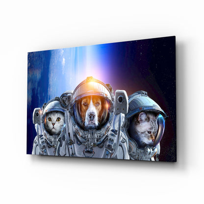 Three astronauts—cat, dog, and monkey—in spacesuits against starry blue backdrop on angled glass panel.