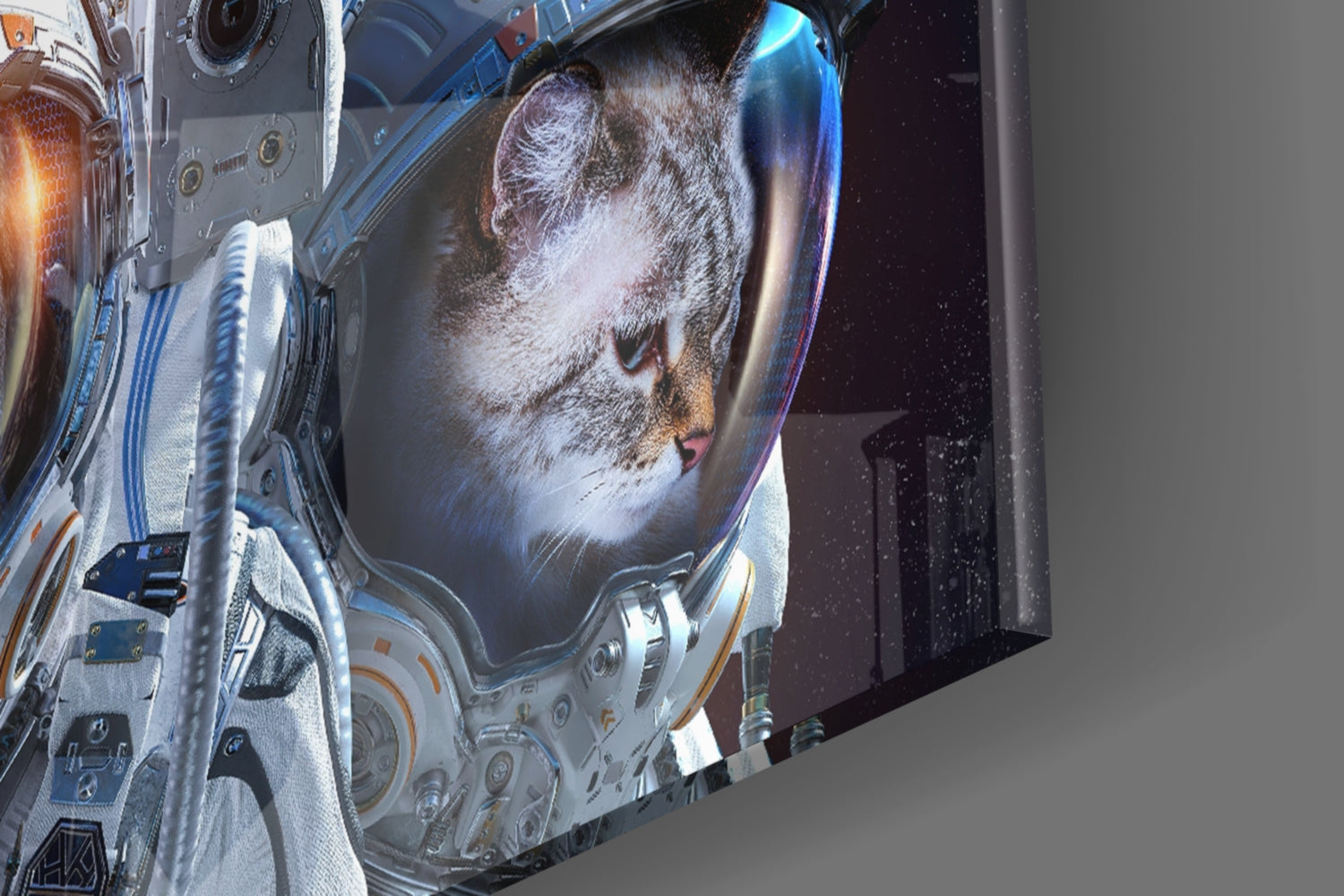 Close-up of glass wall art showing astronaut in white spacesuit with cat's face visible in helmet visor against starry space background.