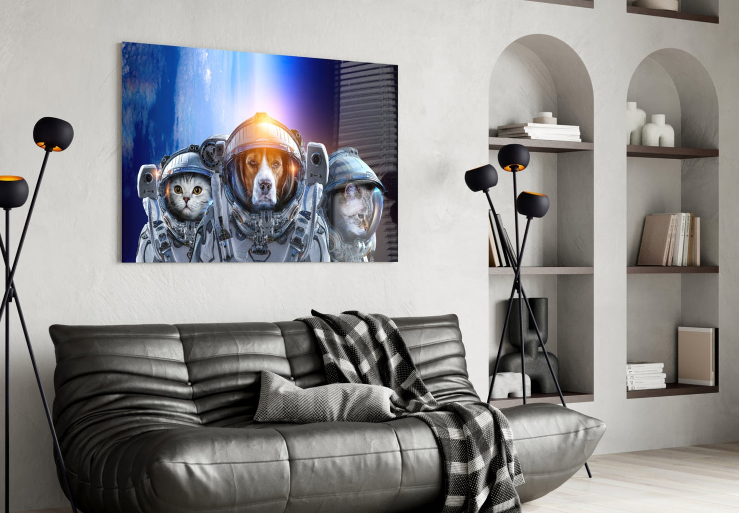 Modern living room with black leather sofa displaying glass wall art of three animals in astronaut suits above it.